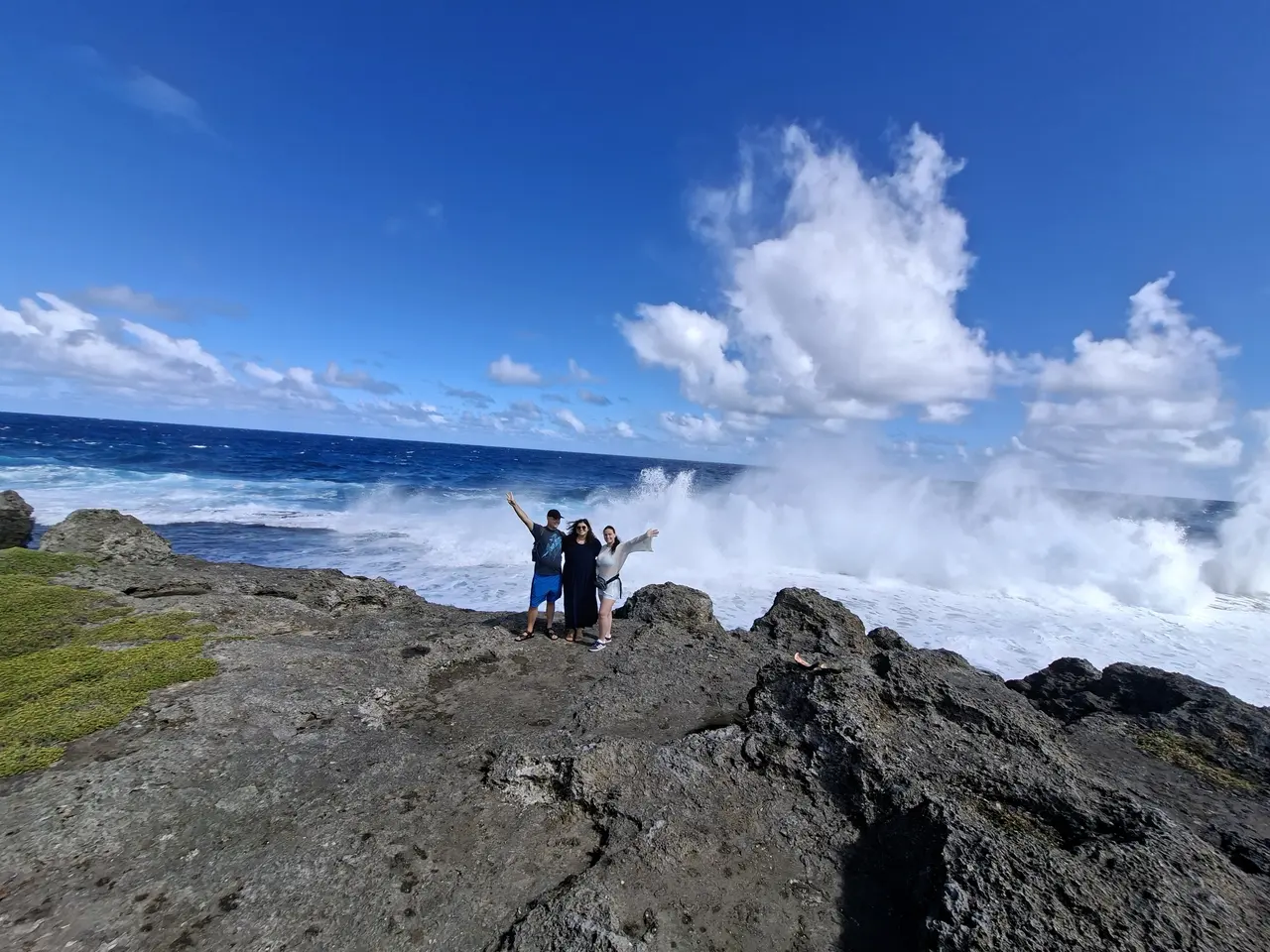 Tour guests watching waves break along Tongatapu's rocky coast